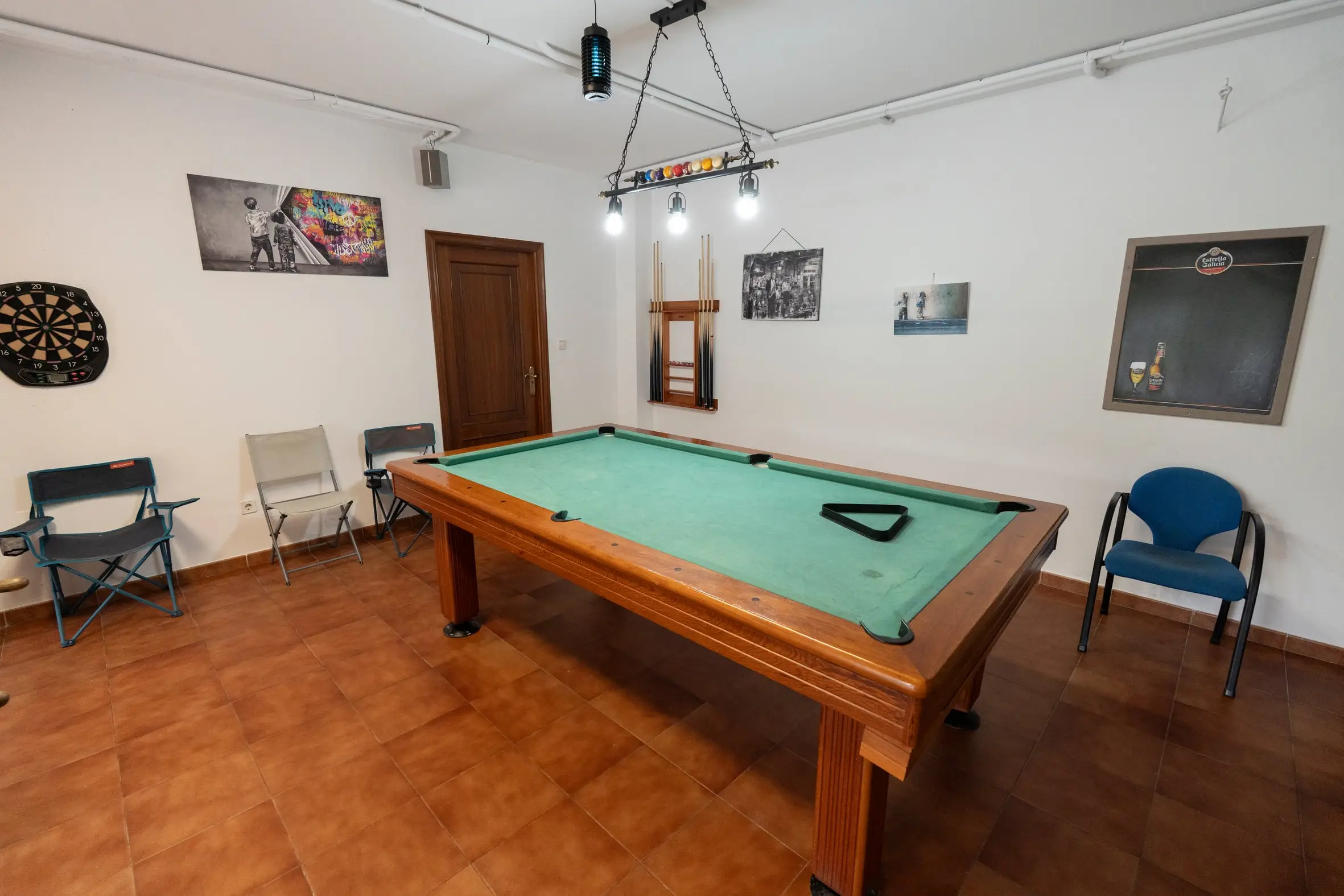 Mesa de billar americano con diana de dardos en la sala de juegos
