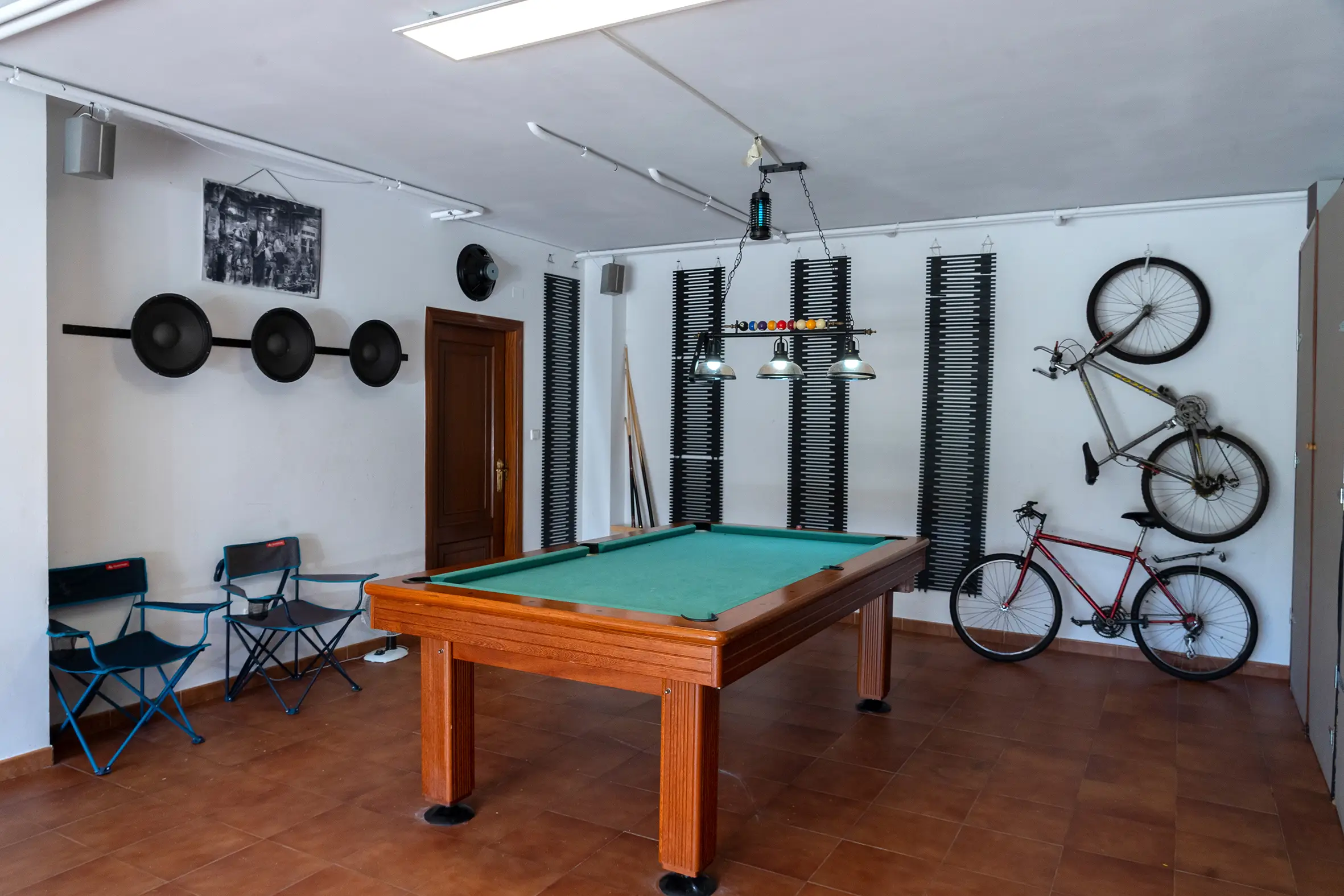 Sala de juegos con mesa de billar profesional y ventanales