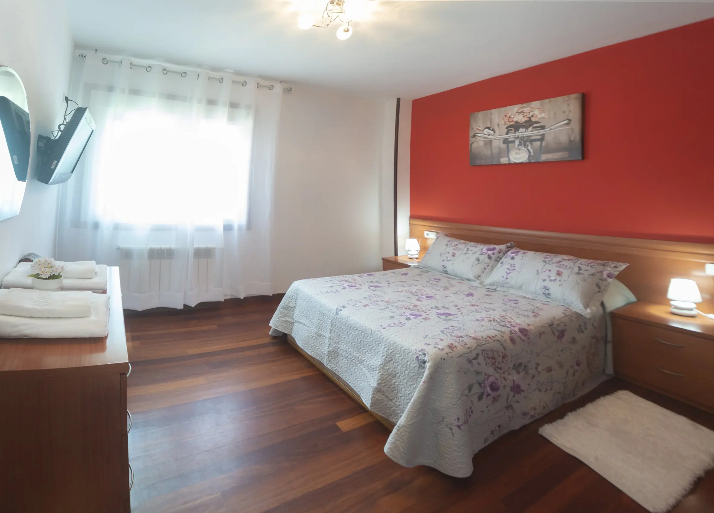 Dormitorio 1 con cama doble, ventanas amplias y decoración rústica moderna