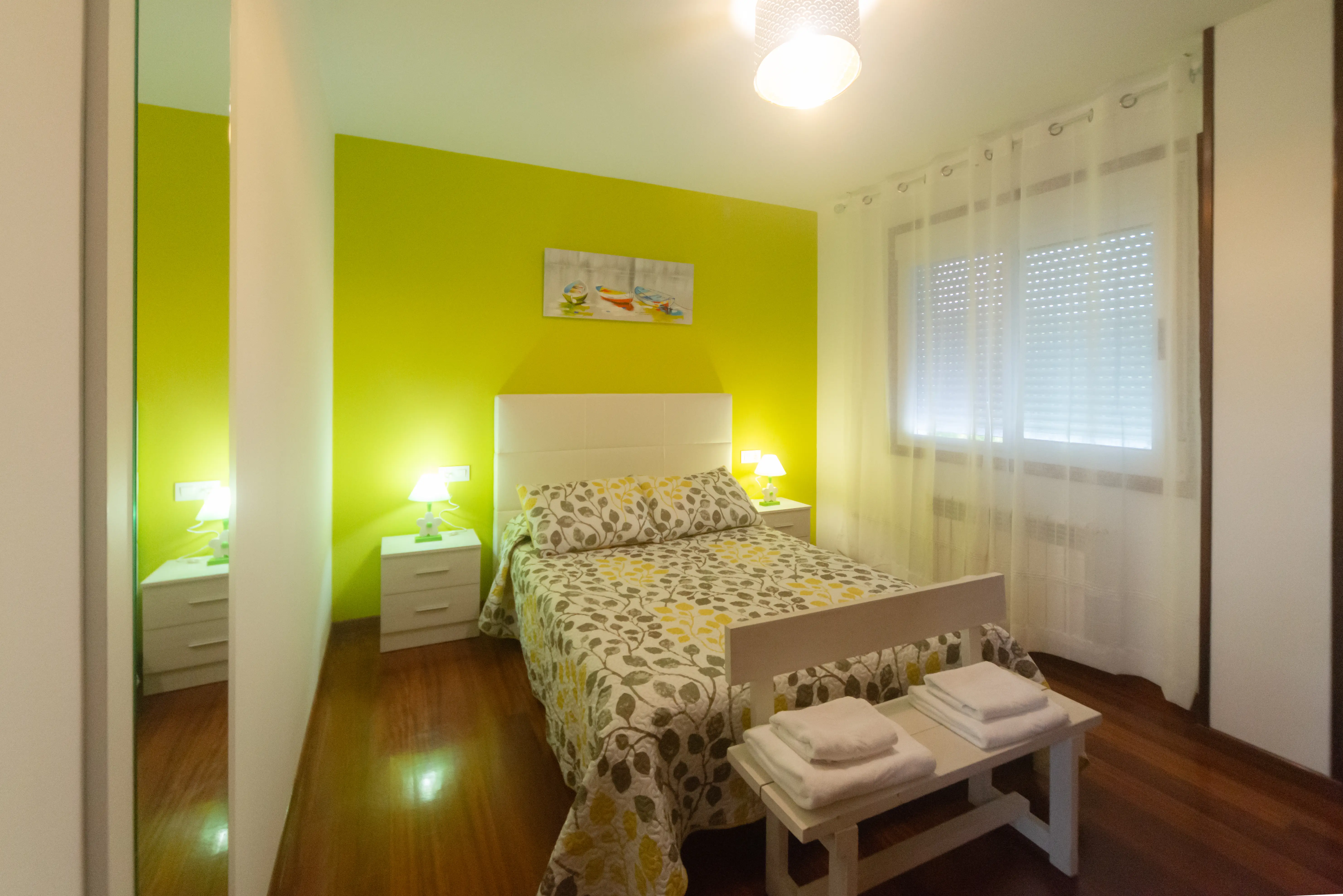 Dormitorio 2 con cama doble, luz natural y detalles en madera