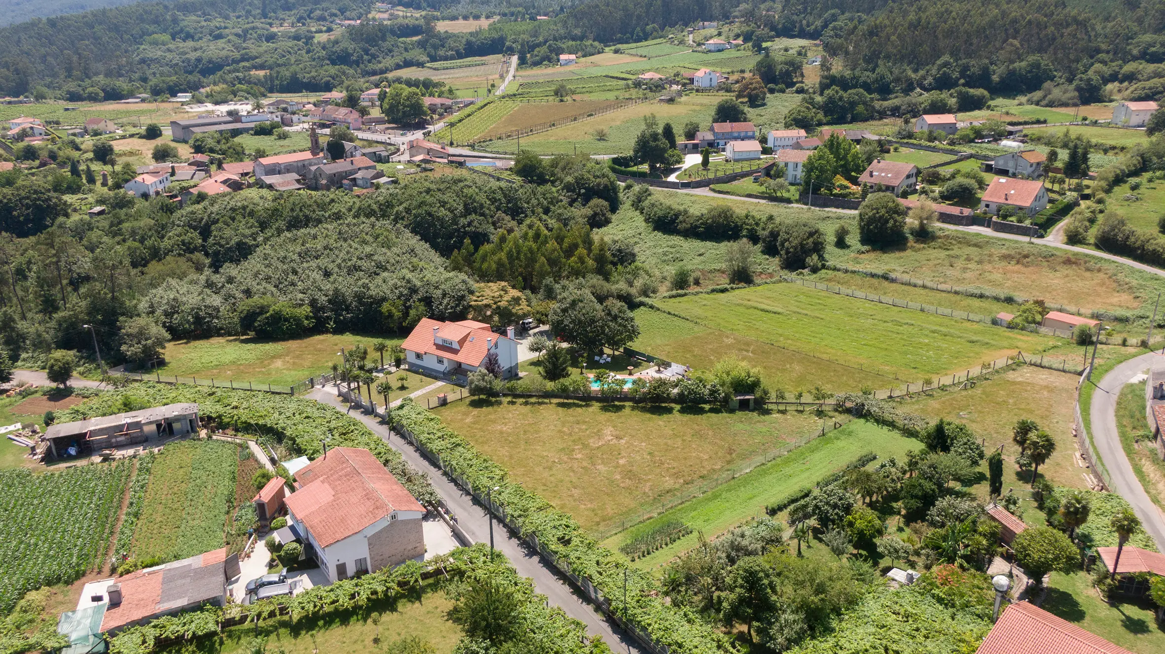 Vista frontal de A Casa de Blanco con fachada de piedra y jardín en Teo, Galicia