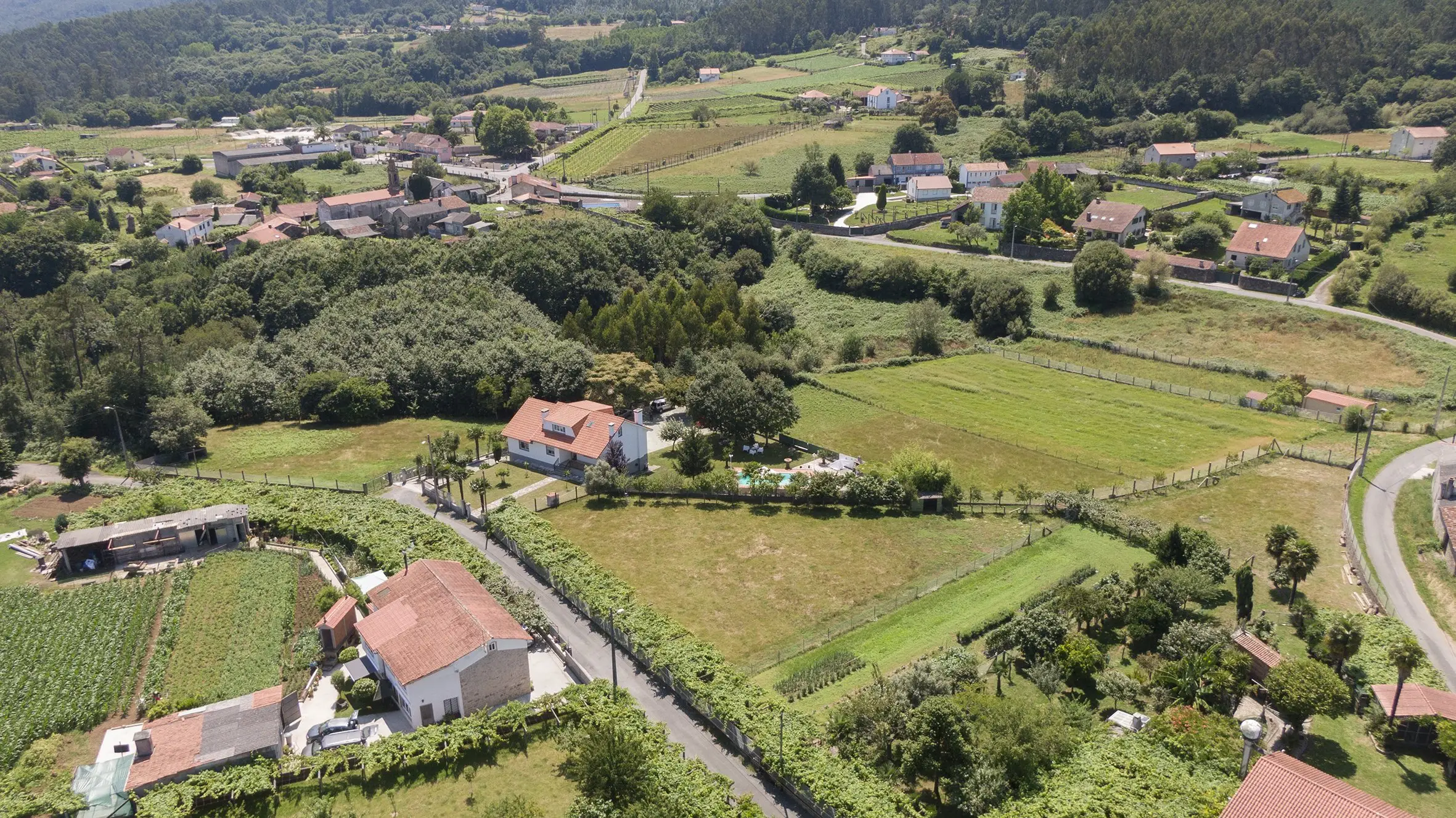 Vista frontal de A Casa de Blanco con fachada de piedra y jardín en Teo, Galicia