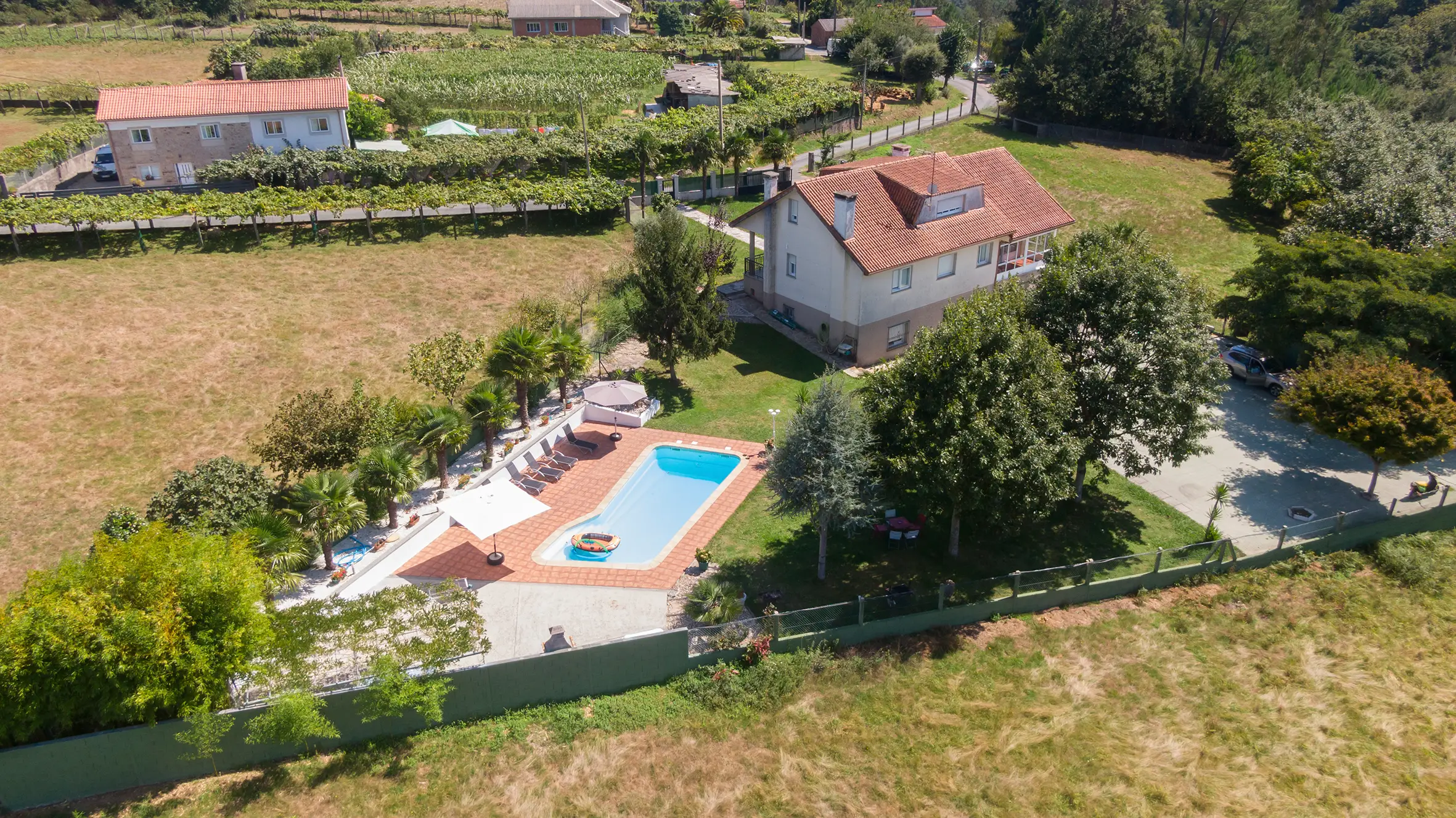 Vista panorámica de A Casa de Blanco con jardín, piscina y entorno natural en Galicia