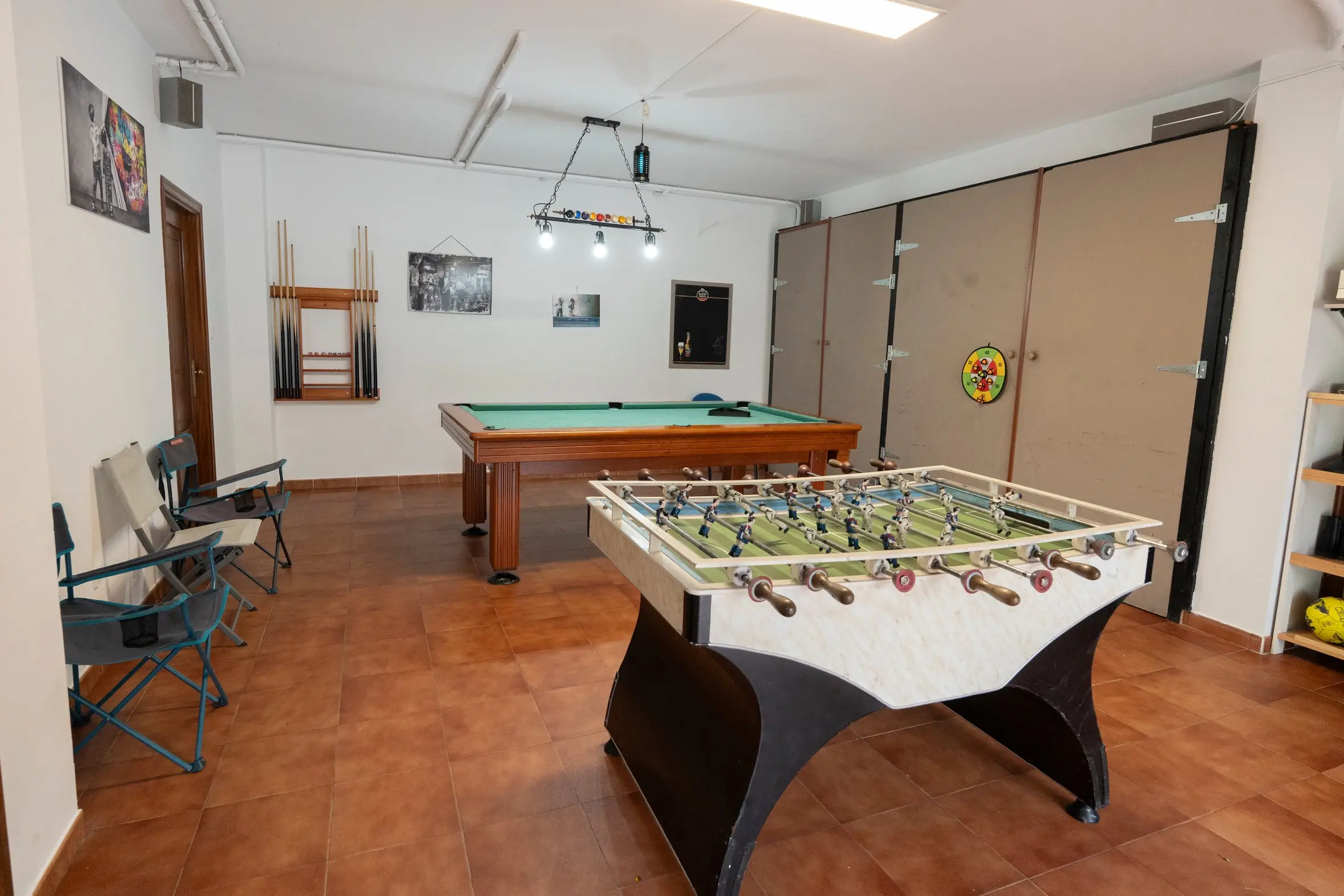 Sala de juegos con mesa de billar y futbolín para toda la familia