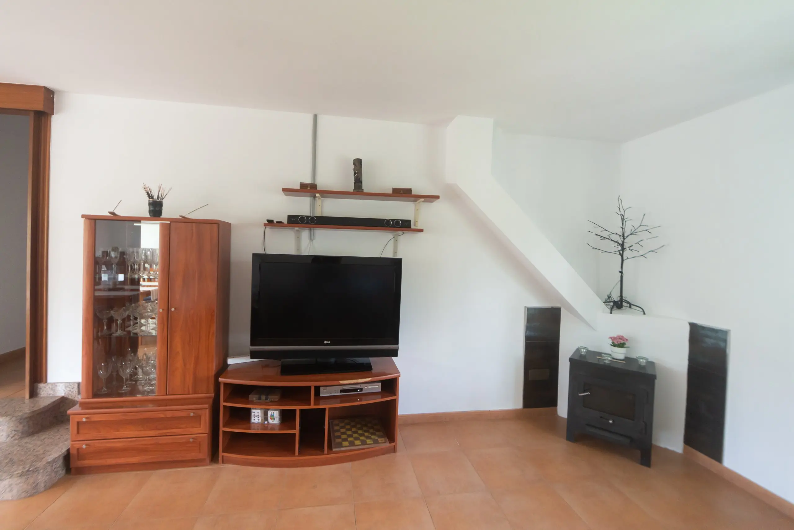 Salón principal con chimenea de piedra, sofás amplios y televisión