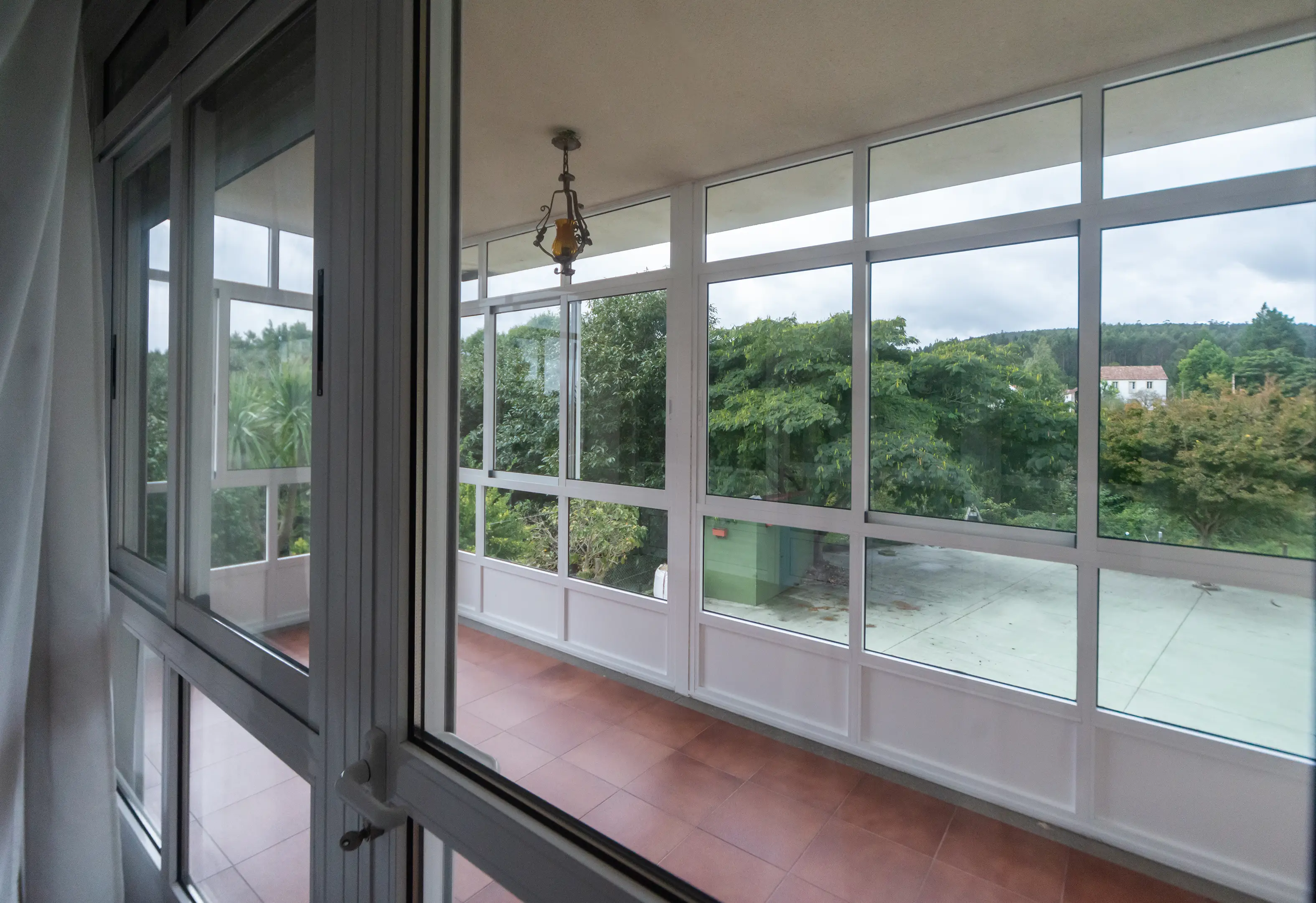 Galería cubierta con sofás y vistas al jardín para relajarse